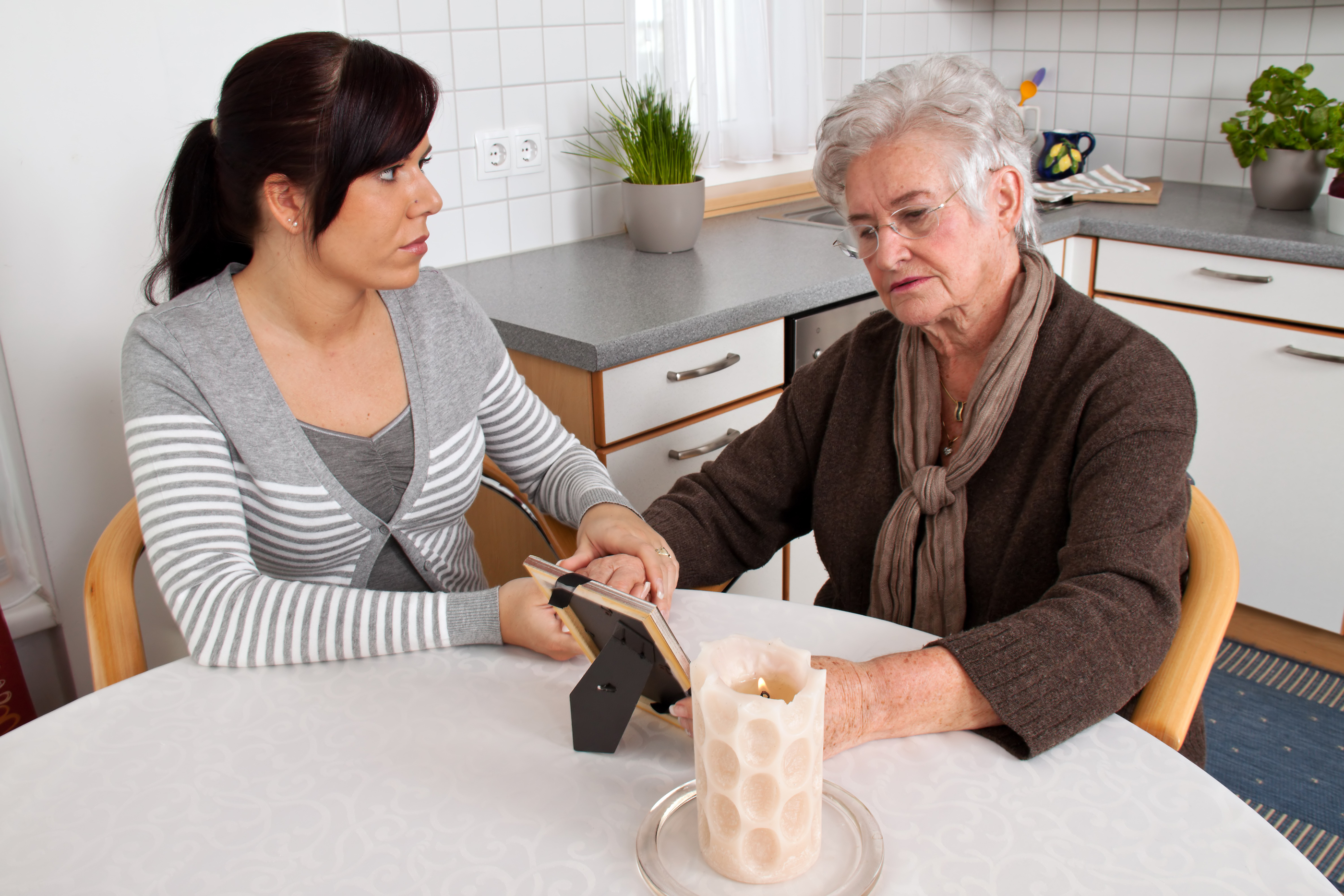 A young woman comforting a widow after death. Bereavement support.